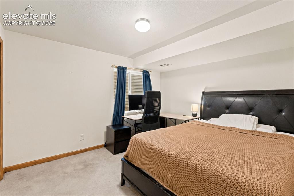 Image 22 of 34: Carpeted room featuring a window with horizontal blinds, a wood door frame,