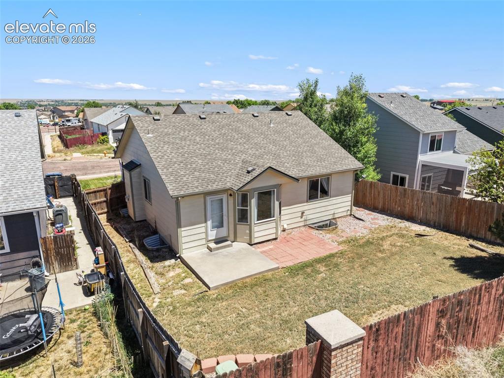 Image 25 of 34: Rear exterior featuring a concrete patio, brick paver patio, and fenced yar