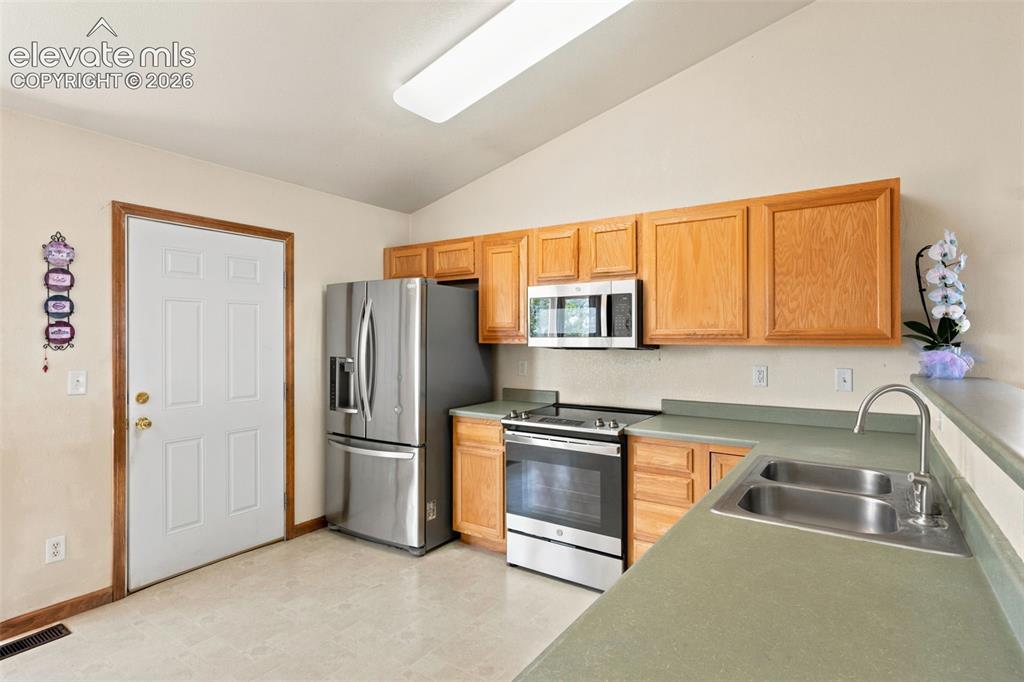Image 9 of 34: Kitchen featuring light wood cabinetry, stainless steel appliances, a doubl