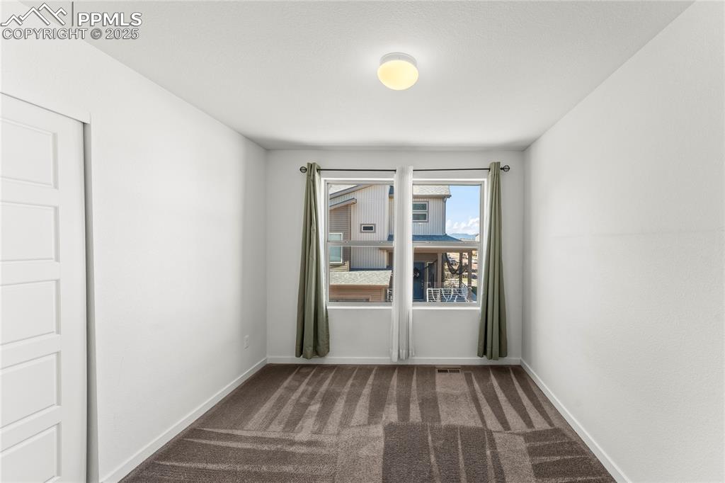 Image 14 of 33: Spare room with dark carpet