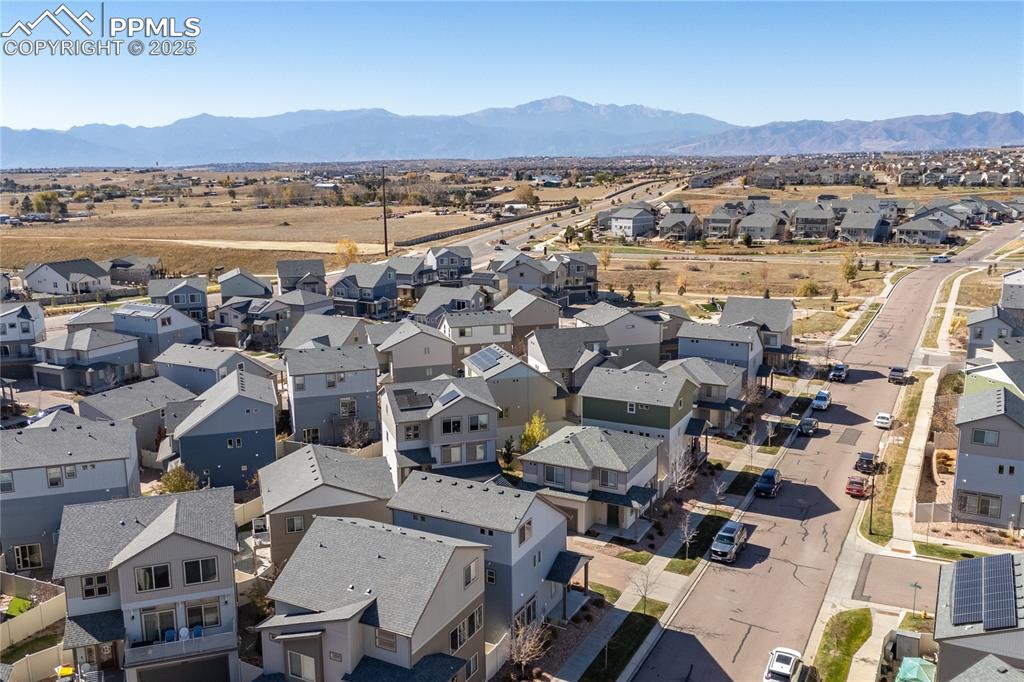 Image 29 of 33: Aerial view of residential area featuring a mountainous background