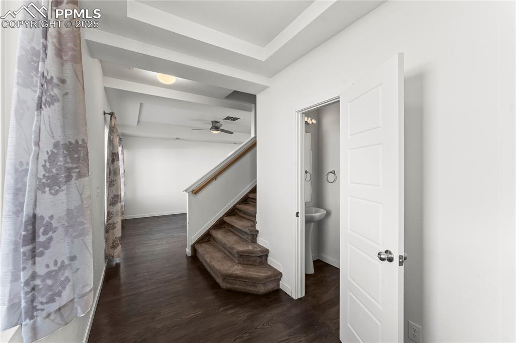 Image 3 of 33: Stairs with wood finished floors and a ceiling fan