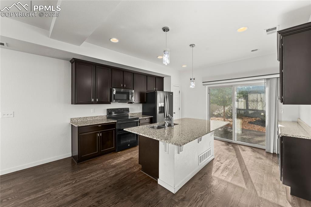 Image 5 of 33: Kitchen with appliances with stainless steel finishes, light stone counters
