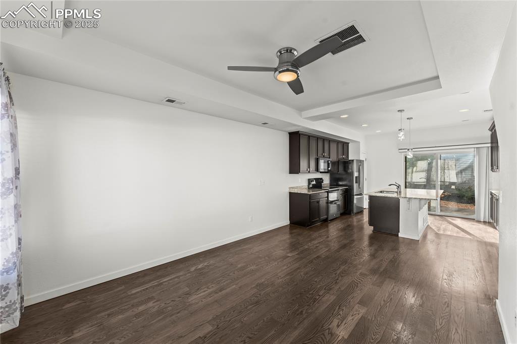 Image 9 of 33: Kitchen with dark wood-type flooring, range with two ovens, decorative ligh