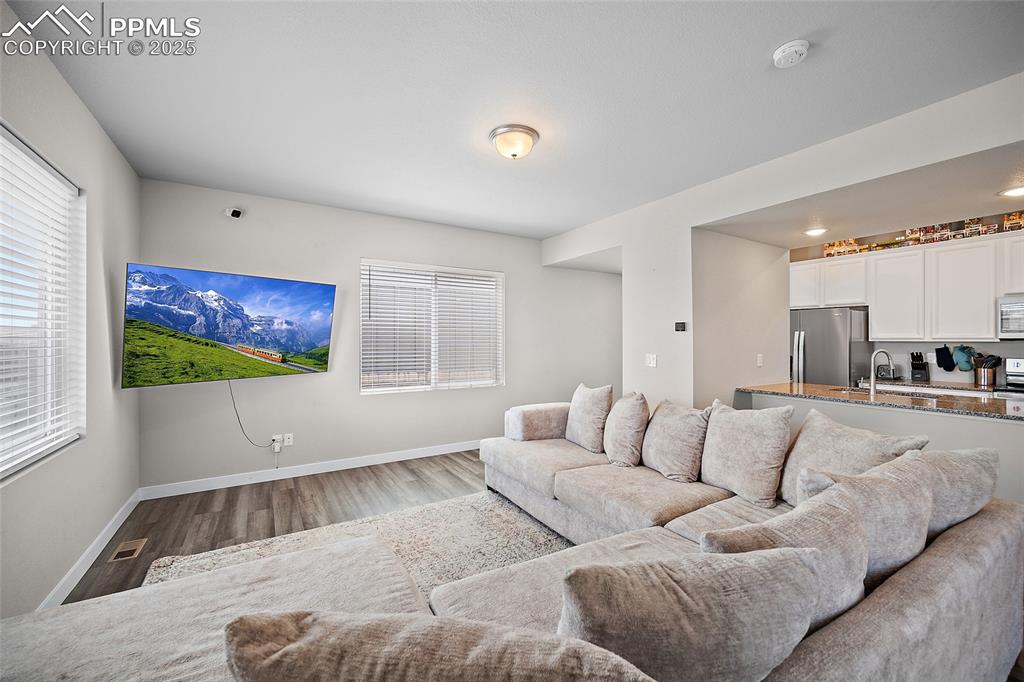 Image 10 of 41: Living area with baseboards, wood finished floors, and healthy amount of na