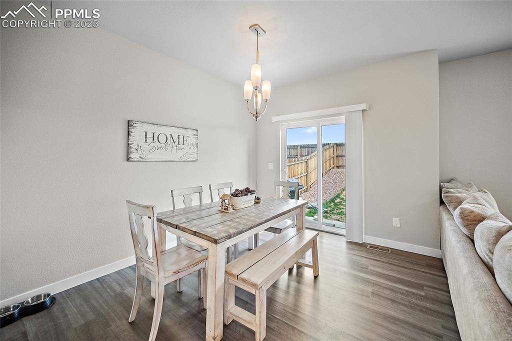 Image 15 of 41: Dining room featuring baseboards, a chandelier, and dark wood-type flooring