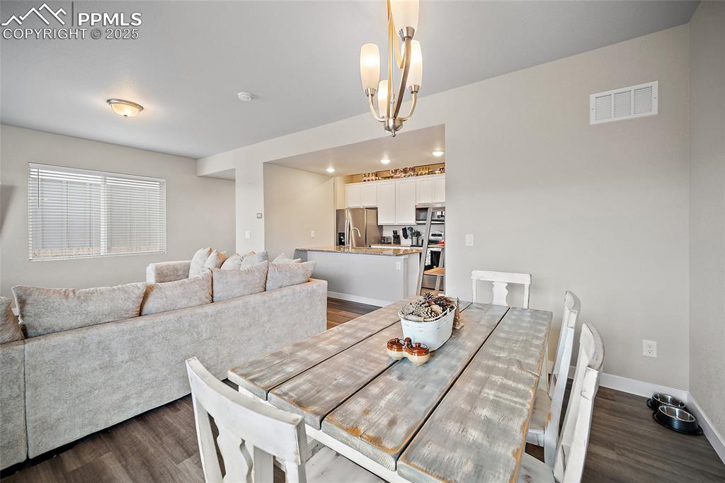 Image 16 of 41: Dining space with dark wood-style flooring and baseboards