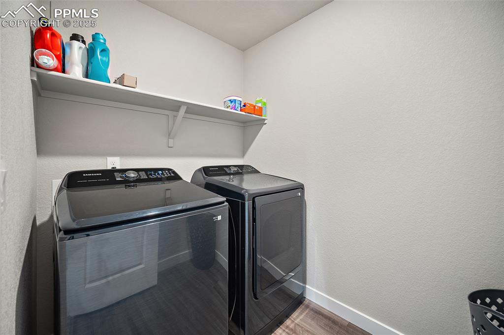 Image 17 of 41: Laundry area with separate washer and dryer, baseboards, and wood finished