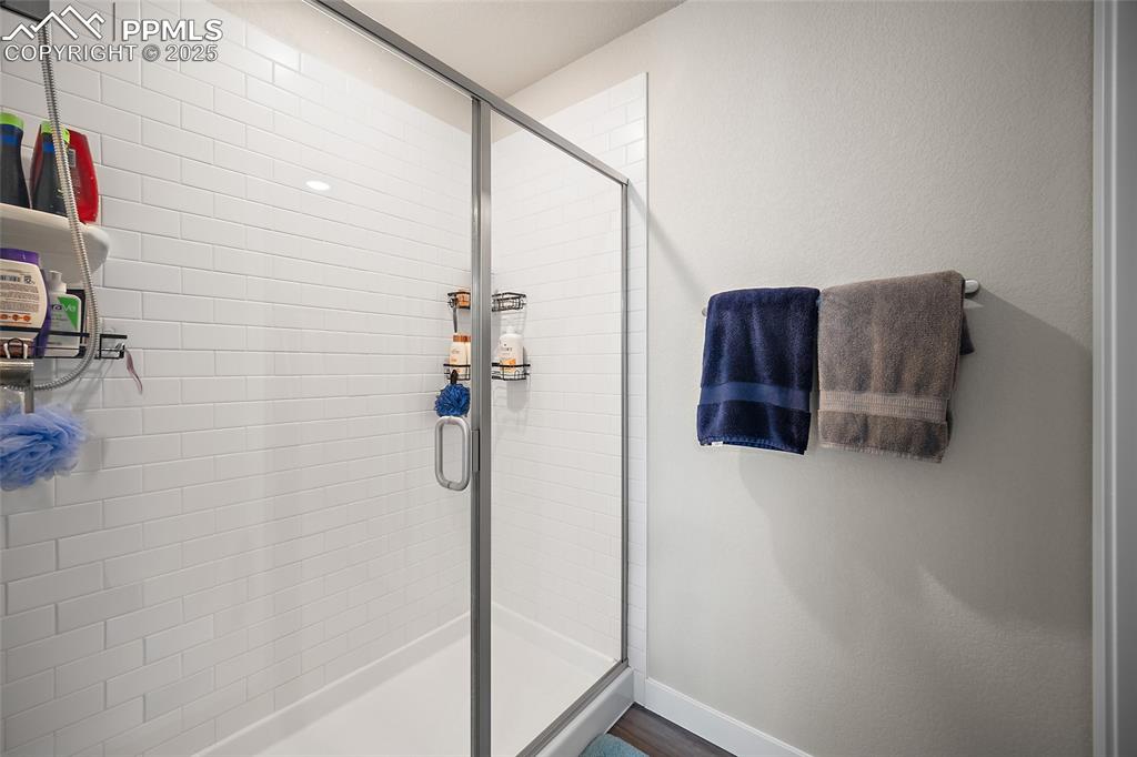 Image 26 of 41: Bathroom with a shower stall and baseboards