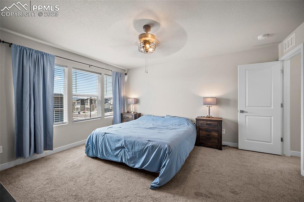 Image 28 of 41: Bedroom featuring carpet flooring, baseboards, a ceiling fan, and a texture