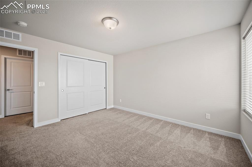 Image 30 of 41: Unfurnished bedroom with carpet, baseboards, and a closet