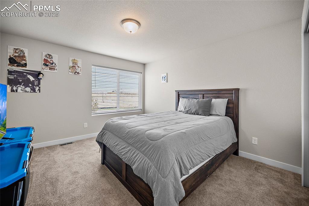 Image 33 of 41: Bedroom with carpet floors and baseboards
