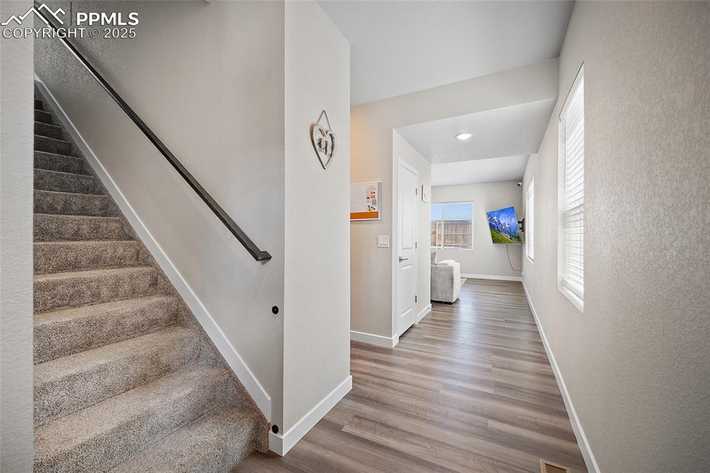 Image 5 of 41: Stairs featuring baseboards, wood finished floors, and recessed lighting