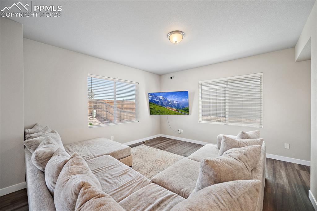 Image 9 of 41: Living room with baseboards and dark wood-style flooring