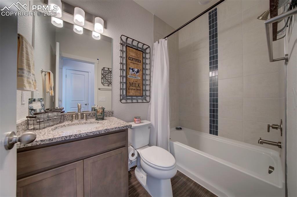 Image 21 of 42: Full bathroom featuring vanity, shower / tub combo with curtain, wood finis