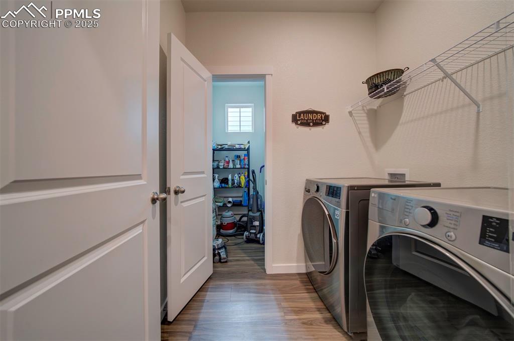 Image 25 of 42: Laundry area featuring washing machine and dryer, wood finished floors, and