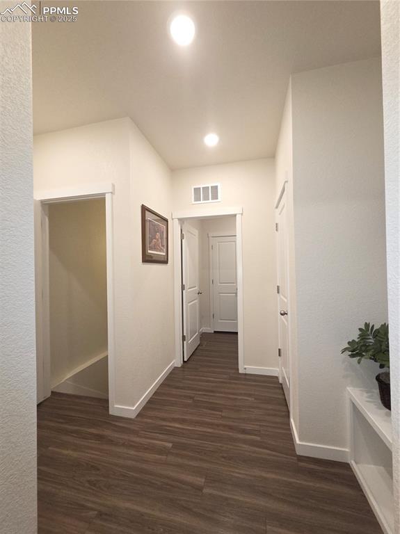 Image 26 of 42: Corridor featuring dark wood-type flooring and recessed lighting