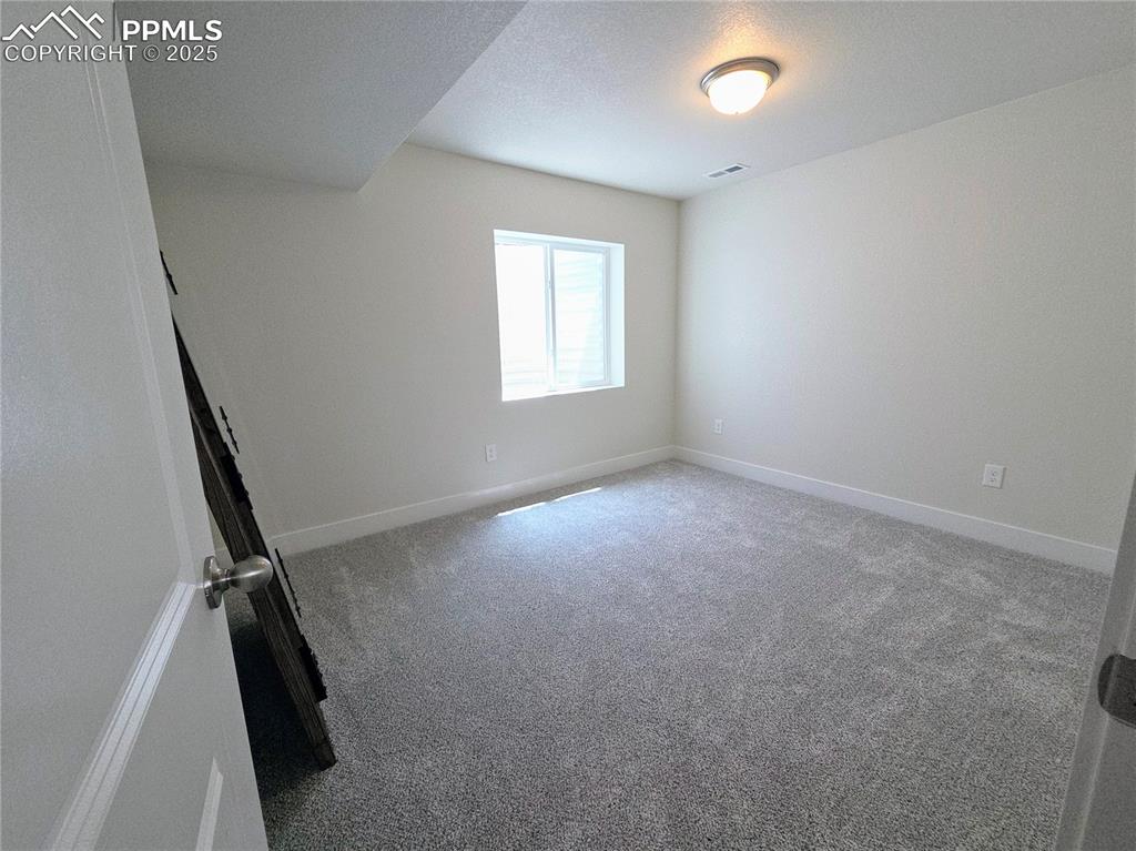 Image 29 of 42: Carpeted spare room with baseboards