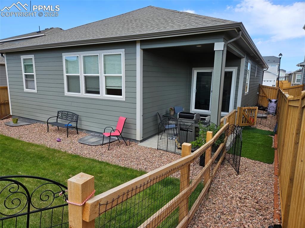 Image 37 of 42: Rear view of house with a fenced and dog runbackyard, roof with shingles, a