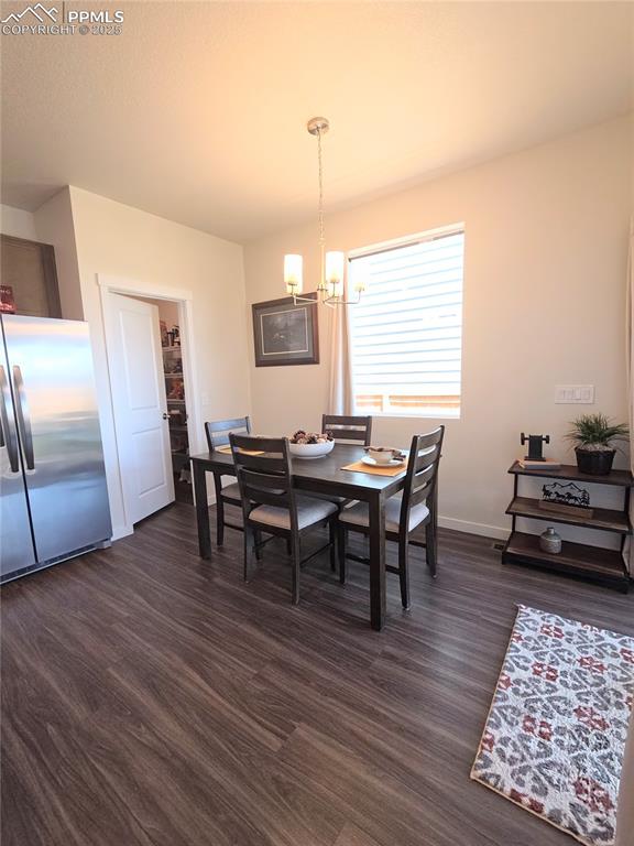 Image 7 of 42: Dining area featuring a chandelier and dark wood finished floors