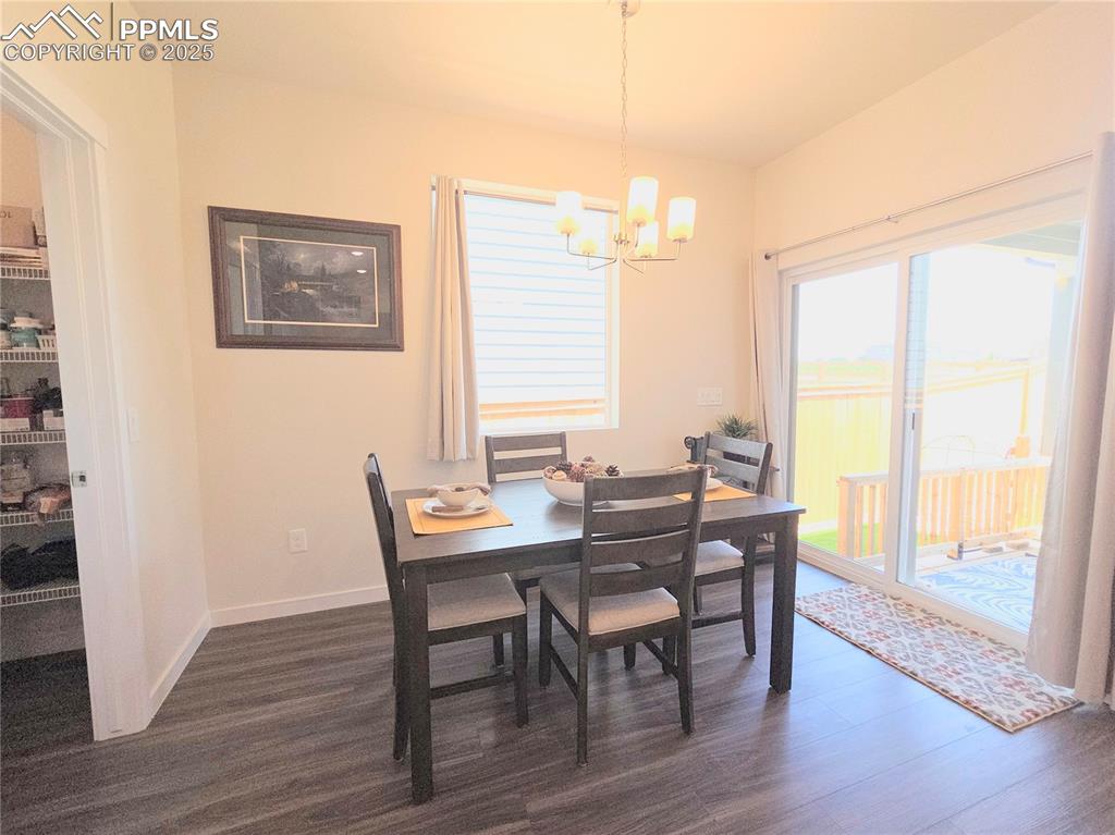 Image 9 of 42: Dining area with a chandelier and dark wood-style flooring