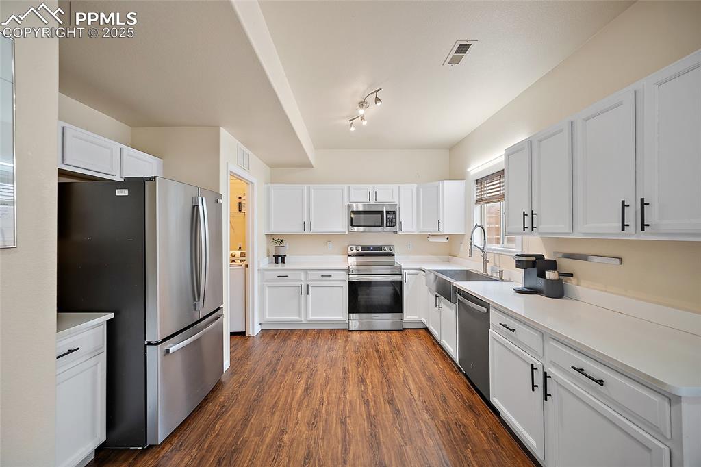 Image 11 of 50: Kitchen featuring appliances with stainless steel finishes, light counterto