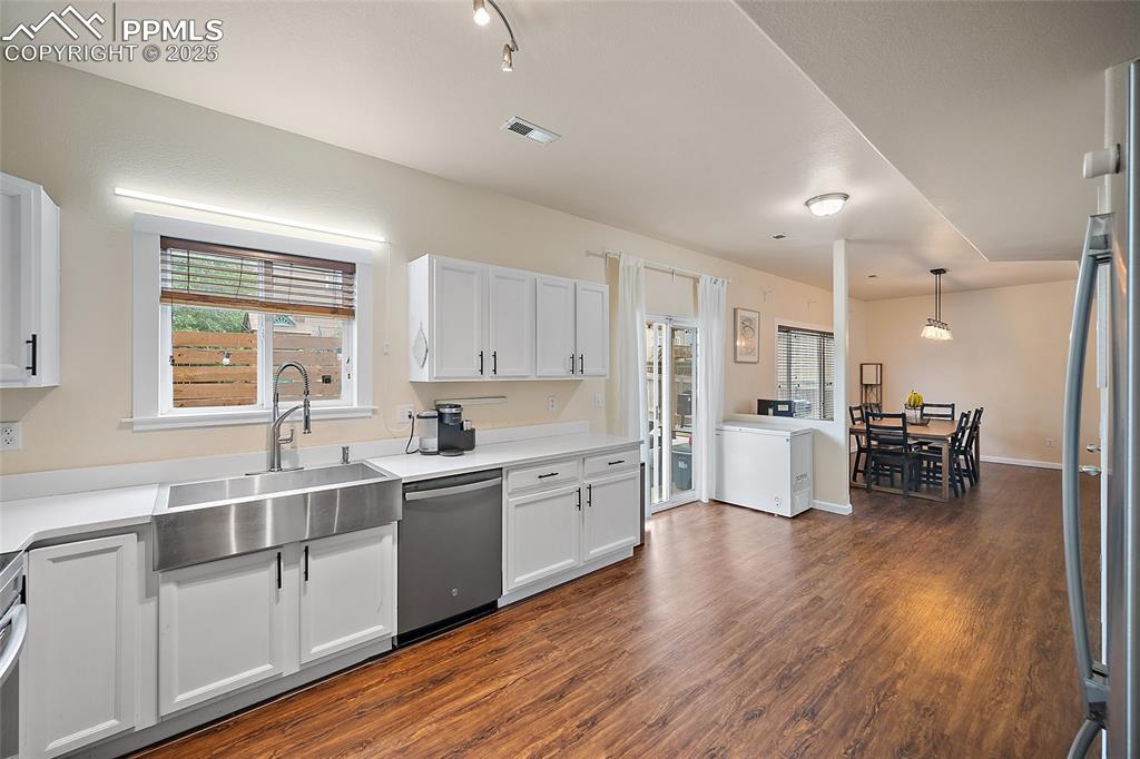 Image 12 of 50: Kitchen featuring white cabinetry, dark wood finished floors, appliances wi