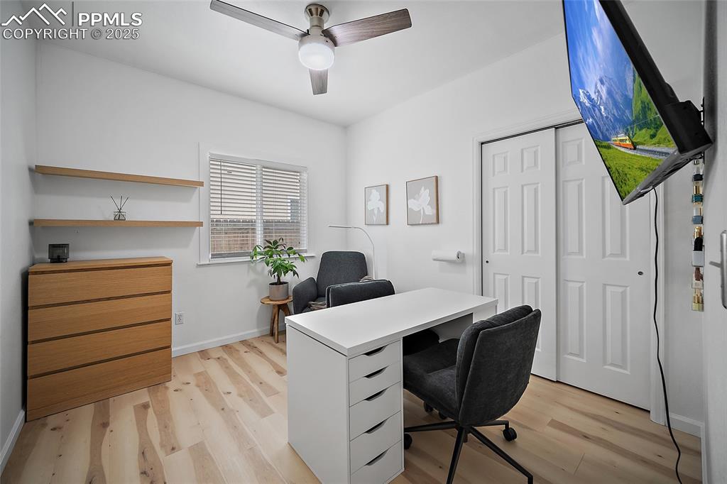 Image 17 of 50: Office area featuring light wood-style flooring and a ceiling fan