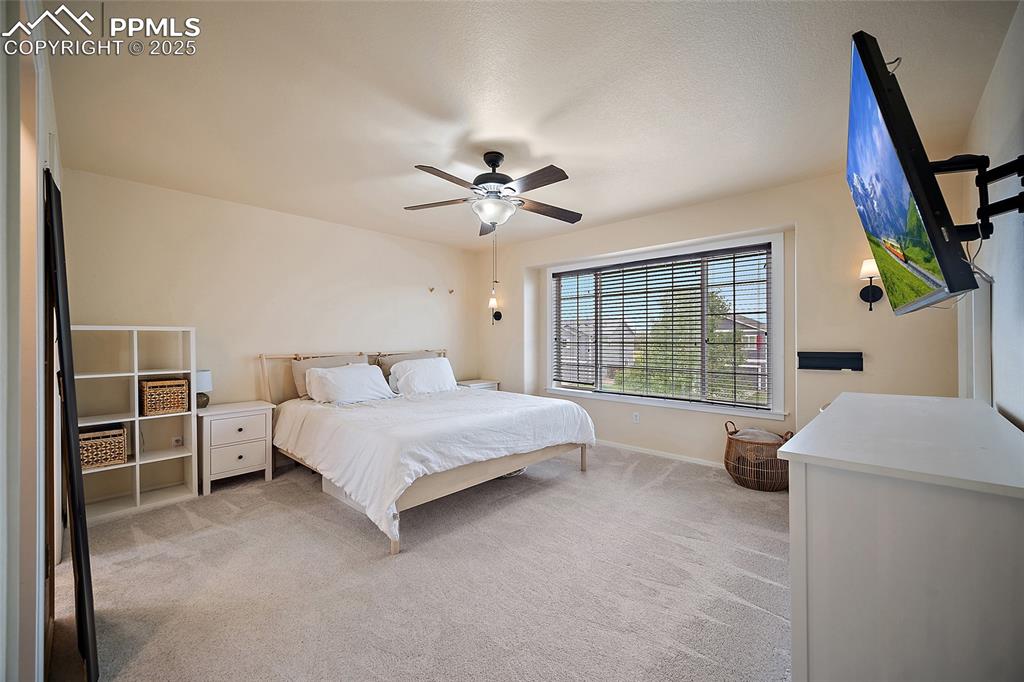 Image 20 of 50: Bedroom featuring light carpet and ceiling fan