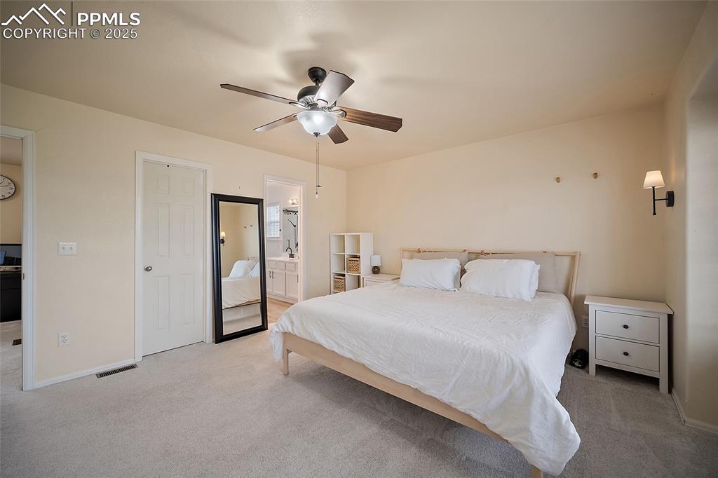 Image 21 of 50: Bedroom featuring carpet flooring, a ceiling fan, and ensuite bathroom