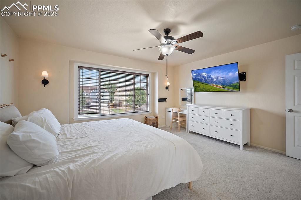 Image 22 of 50: Bedroom featuring light colored carpet and a ceiling fan