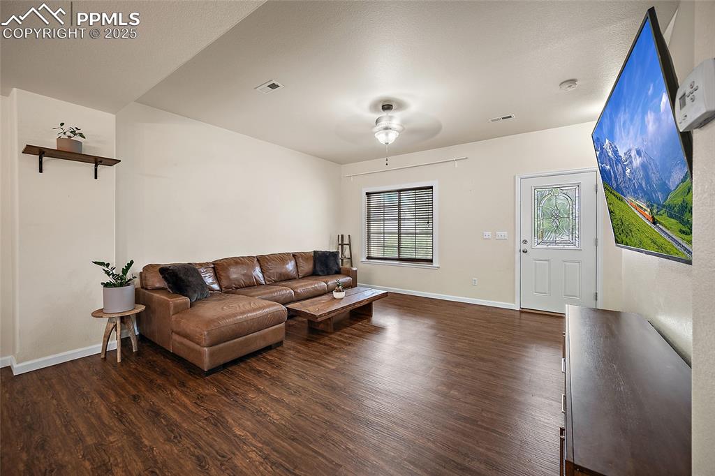Image 5 of 50: Living area featuring dark wood finished floors and ceiling fan