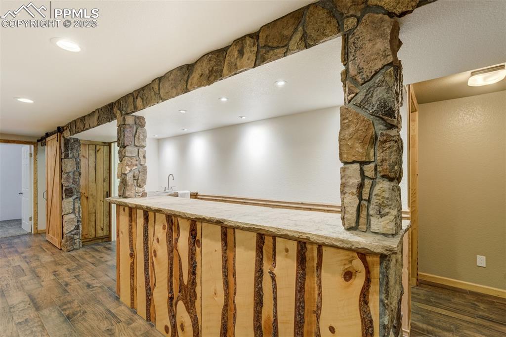 Image 26 of 50: Bar with custom stone and live edge pine wood