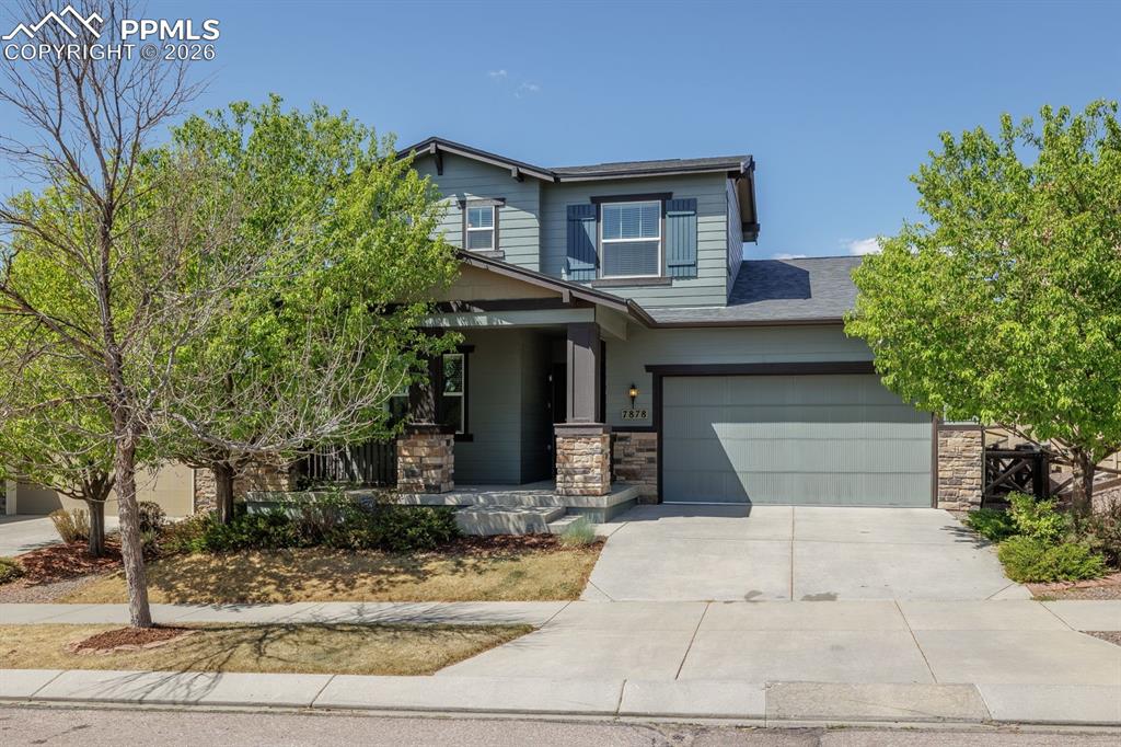 Caption: Two-story property featuring a stone and siding exterior, an attached two-car garage, and a covered 