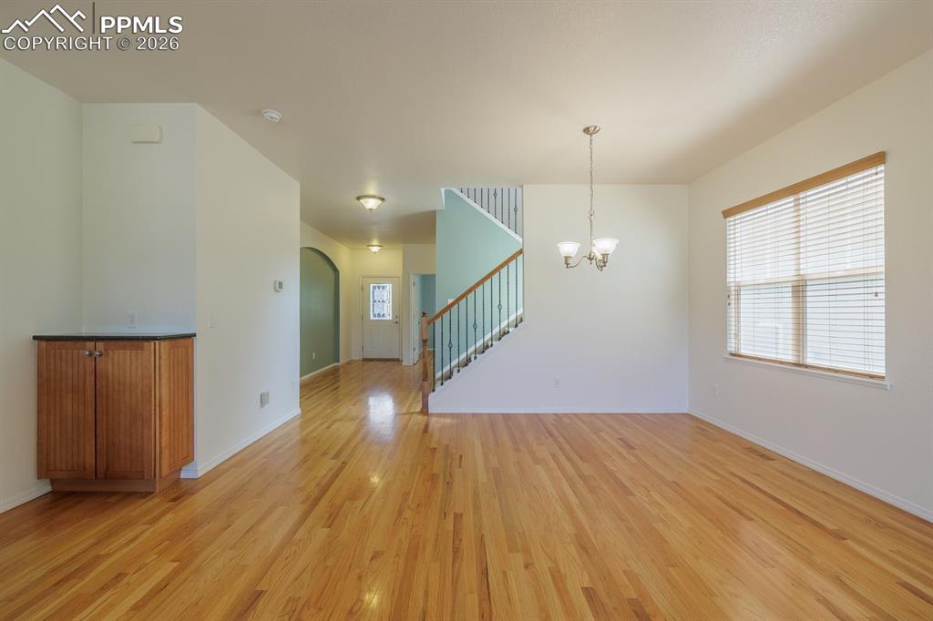 Image 13 of 50: Entryway featuring wood-finish flooring, a white front door with decorative