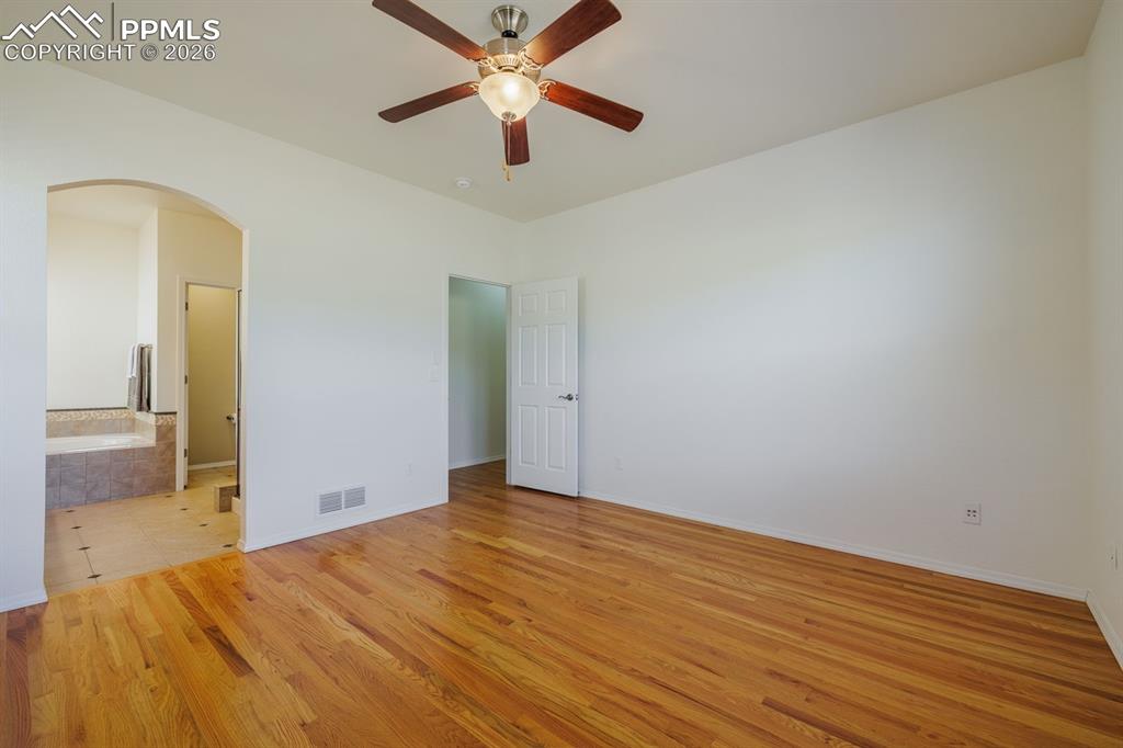 Image 24 of 50: Hardwood flooring throughout a spacious room featuring a fireplace with a s