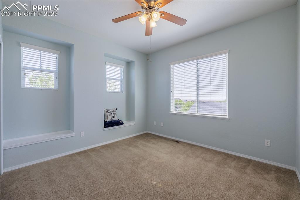 Image 31 of 50: Spacious room featuring wood-finish flooring, multiple windows with blinds,