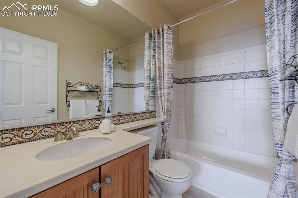 Image 33 of 50: Dual vanity with granite countertops, undermount sinks, and mosaic tile bac