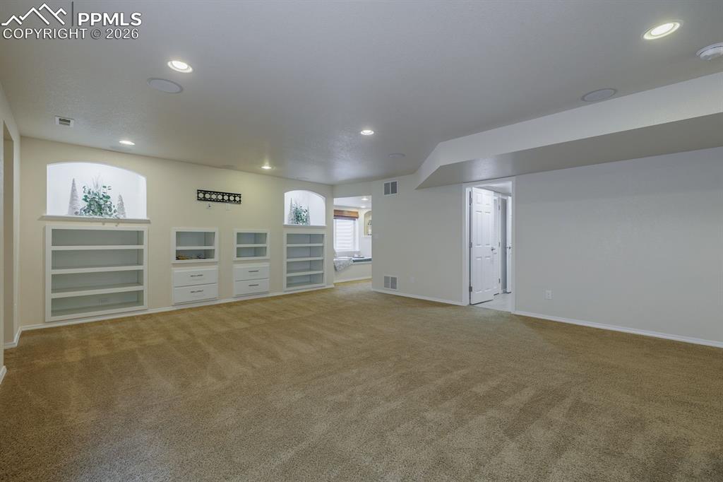 Image 35 of 50: Walk-in closet featuring wire shelving, wall-to-wall carpeting, and wood-fi