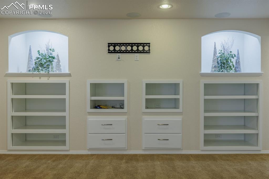 Image 36 of 50: Built-in shelving storage featuring wood-finish shelves and white wire rack