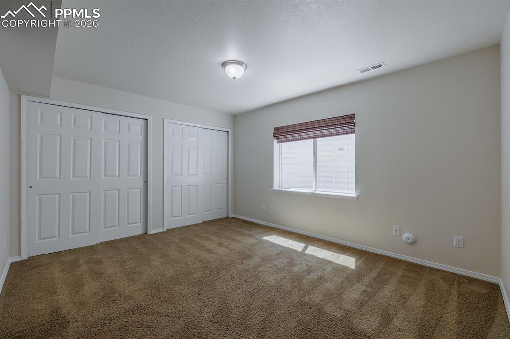 Image 38 of 50: Carpeted interior room featuring light-colored walls, white trim, and a whi