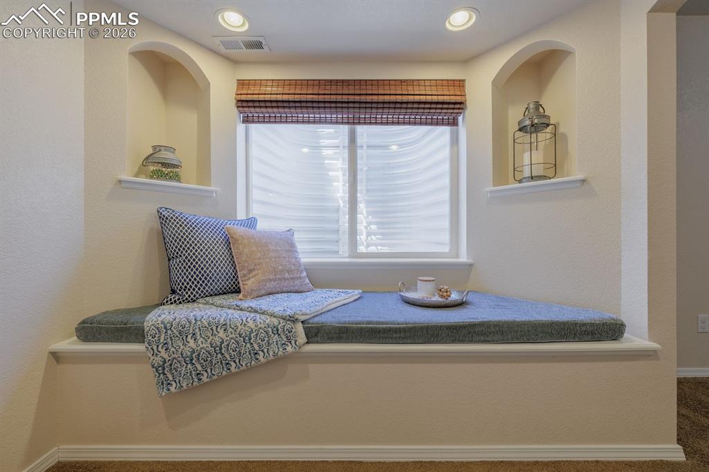 Image 43 of 50: Spacious room featuring neutral carpeting, recessed lighting, built-in shel