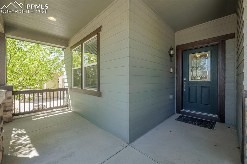 Image 5 of 50: Contemporary exterior featuring a covered porch with stone-clad columns, a