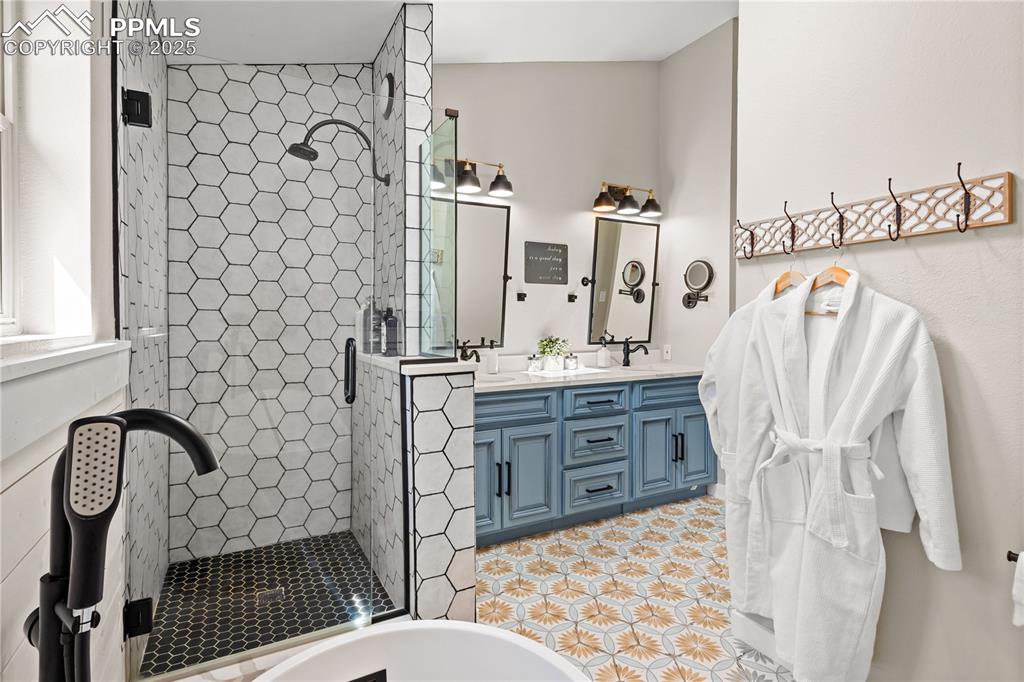 Image 20 of 48: Bathroom with tile flooring, shower with separate bathtub, and double vanit