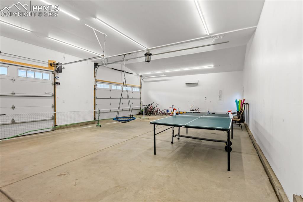 Image 42 of 48: Four car garage has lots of lights and currently used for indoor fun at the
