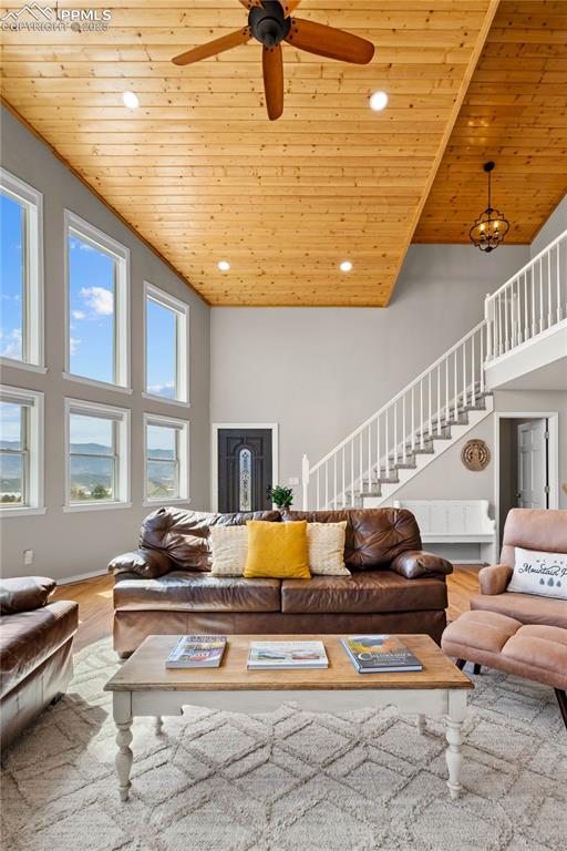 Image 5 of 48: Living room with vaulted wood ceilings, fan, and large windows showing the 