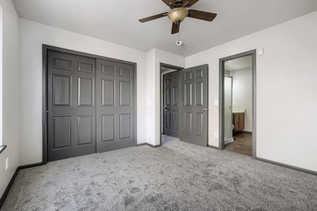 Image 10 of 27: Spacious room featuring gray carpet, light gray walls, dark gray trim, and 