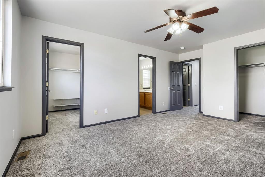 Image 11 of 27: Carpeted room featuring a ceiling fan with light fixture, multiple doorways