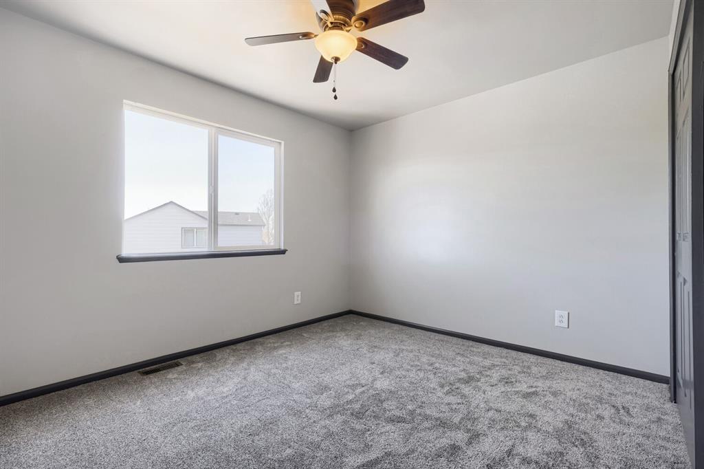 Image 16 of 27: Carpeted interior space featuring a window with dark trim, light gray walls