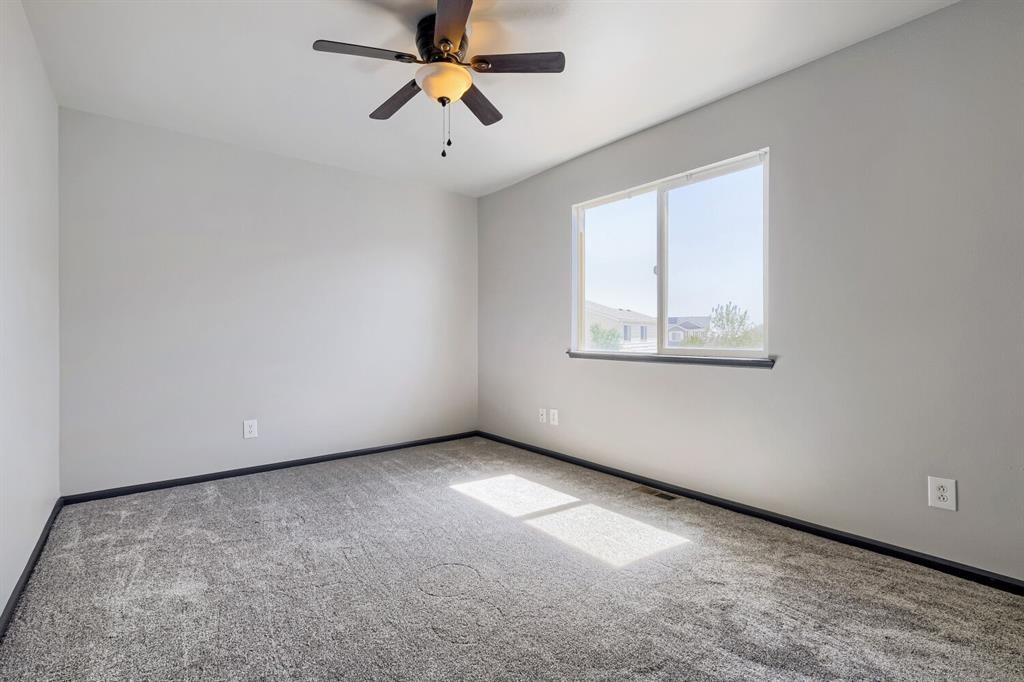 Image 17 of 27: Spacious room featuring light gray walls, dark trim, and gray carpet floori